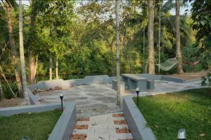 a park with a bench and some trees at Neerbhoomi in Kollam +3 photos
