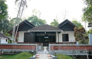 a house with a fence in front of it at Neerbhoomi in Kollam