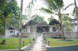 a house with a fountain in front of a yard at Neerbhoomi in Kollam