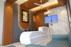 a waiting room with a tv and a white chair at Hotel Barai Palace in Dwarka