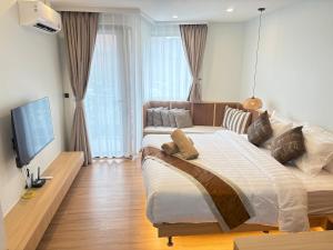 a bedroom with a large bed and a flat screen tv at Wing Samui Condo 102 in Nathon Bay +22 photos