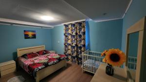 a bedroom with a crib and a blue wall at my home in Kutaisi