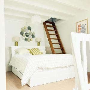 a bedroom with a white bed and a staircase at Chalet Le Reposou in Laguiole