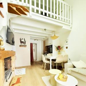 a living room with white walls and a white table and chairs at Chalet Le Reposou in Laguiole