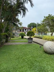 a yard with grass and trees and a house at Hotel Saumya Polhena in Matara