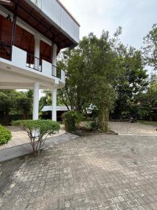 a building with a brick courtyard in front of it at Hotel Saumya Polhena in Matara