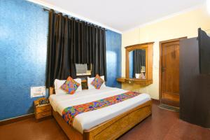 a bedroom with a large bed in a room at FabHotel Vardhmaan Inn in New Delhi