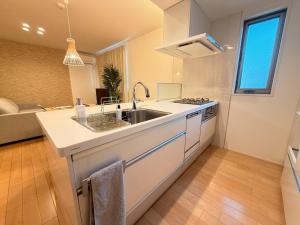 a white kitchen with a sink and a stove at Franmare in Okayama +28 photos