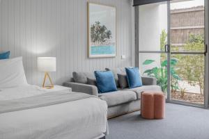 a bedroom with a bed and a couch at Bay View Style in Lorne