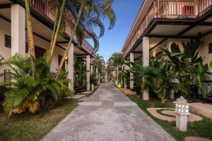 a walkway between two buildings with palm trees at Blue Bay Resort - Access to Pool and Beach-Phuket & Krabi in Ko Yao Yai