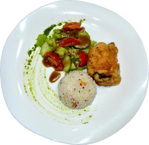 a white plate of food with rice and vegetables at Guide Hotel in Ulaanbaatar