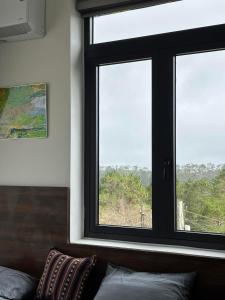 a window in a room with a couch in front at XƠ ĐĂNG homestay in Kon Plong