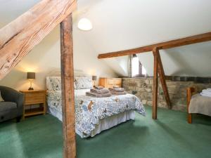 a bedroom with a bed and a stone wall at Redstart Cottage in Leominster