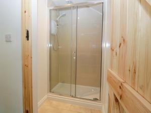 a shower with a glass door in a bathroom at Redstart Cottage in Leominster +17 photos