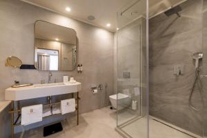 a bathroom with a shower and a sink and a toilet at East Plaza Hotel in Sofia
