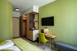 a hotel room with a bed and a desk and a television at Atrium Hotel Krüger in Rostock