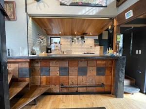 a kitchen with a large counter with wooden cabinets at stylish japanese beach house in Toyohashi