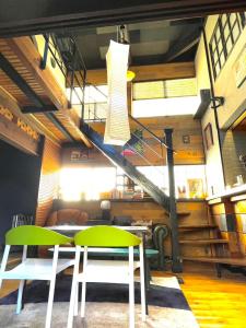 a room with two green chairs and a staircase at stylish japanese beach house in Toyohashi