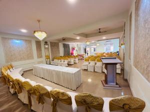 a banquet hall with white tables and chairs at Hotel Raj Kothi Jaipur airport in Jaipur