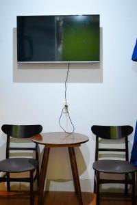 a table with two chairs and a tv on a wall at Restfull apartment-14 Mai Thuc Lan, My An , Da nang in Danang