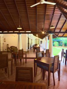 a dining room with wooden tables and chairs at Villa House in Miriswatta