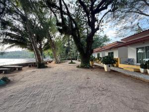 a park with benches and trees and a building at Issara Beach Resort in Sichon +2 photos