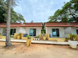 a house with yellow chairs and a palm tree at Issara Beach Resort in Sichon