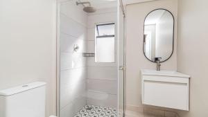 a bathroom with a shower and a sink and a mirror at The Wellington Residence in George
