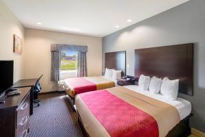 a hotel room with two beds and a television at Econo Lodge Baton Rouge University Area in Baton Rouge