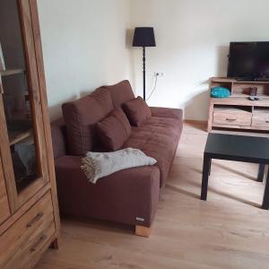 a living room with a brown couch and a desk at Ferienhaus Meiers in Losheim