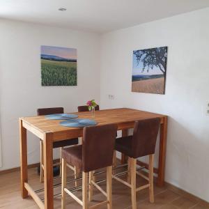 a dining room table with chairs and a painting on the wall at Ferienhaus Meiers in Losheim