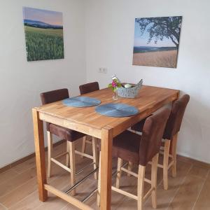 a wooden dining room table with chairs and a painting at Ferienhaus Meiers in Losheim +7 photos