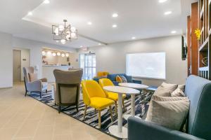 a waiting room with yellow chairs and a table at Comfort Inn & Suites Houma in Houma