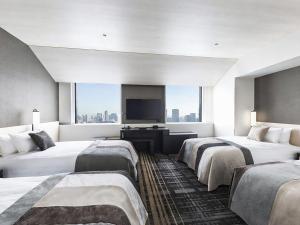 a hotel room with two beds and a flat screen tv at Hotel Hankyu RESPIRE OSAKA in Osaka
