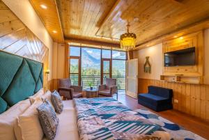 a bedroom with a couch and a tv in a room at The 14 Gables, A Boutique Stay, Manali - Pet Friendly - Balcony Rooms - Crown Palace in Manāli