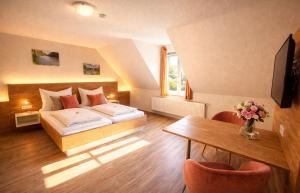 a hotel room with a bed and a table at Hotel Zum Klosterfischer in Blankenburg