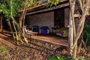 a wooden porch of a house with chairs and a table at petite maison artistique in Saint-Plantaire