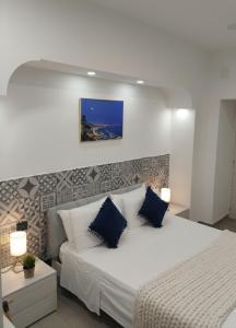 a bedroom with a large white bed with blue pillows at Capodimonte Home in Naples