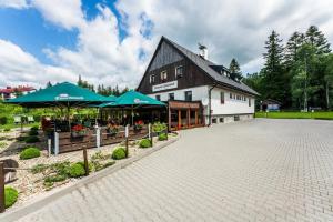 a building with umbrellas in front of a patio at Penzion Neubauer in Ostružná