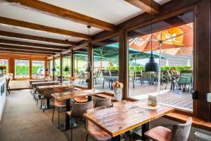 a restaurant with wooden tables and chairs and a patio at Penzion Neubauer in Ostružná