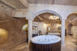 a large bathroom with a tub in a stone wall at Castellum Cave Cappadocia in Uçhisar +73 photos