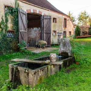 an old house with a water fountain in the yard at petite maison artistique in Saint-Plantaire +4 photos