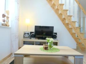 a living room with a table with a tv and stairs at Ferienwohnung Seenlandwinkel in Wackersdorf