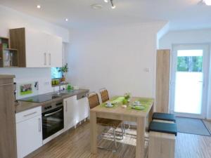 a kitchen with a wooden table and a dining room at Ferienwohnung Seenlandwinkel in Wackersdorf