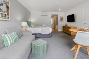 a living room with a couch and a bed at Bay View - Palm Springs in Lorne