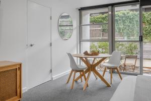 a dining room with a table and white chairs at Bay View - Palm Springs in Lorne