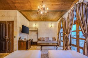 a living room with a couch and a tv at Castellum Cave Cappadocia in Uçhisar