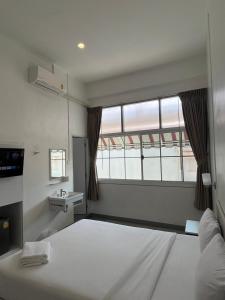 a room with two beds and a window at Muangchan Hotel in Chanthaburi