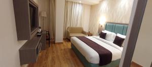 a hotel room with a bed and a television at Aair Hotel And Resorts in Karnal
