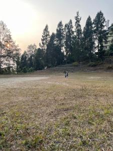 a group of people standing in a large field at Elves Homestay in Rhenok